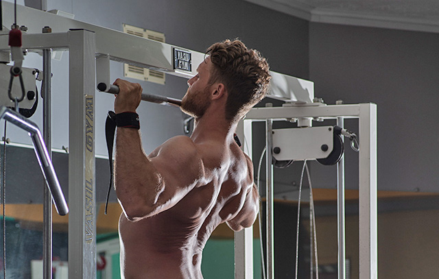 Athlete performing the flexed arm hang test on a pull-up bar